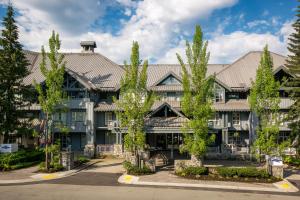 un immeuble d'appartements avec des arbres devant lui dans l'établissement Glacier Lodge, à Whistler