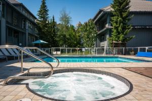 - une piscine avec un bain à remous dans une cour dans l'établissement Glacier Lodge, à Whistler