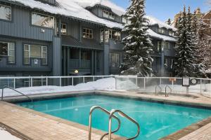 une piscine couverte de neige devant un bâtiment dans l'établissement Glacier Lodge, à Whistler