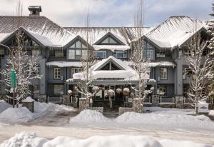 une grande maison recouverte de neige arbres couverts dans l'établissement Glacier Lodge, à Whistler