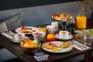 een tafel met borden ontbijtproducten en koffie bij Hotel Felix in Zürich