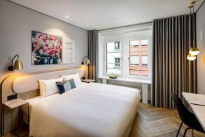 een slaapkamer met een groot wit bed en een bureau bij Hotel Felix in Zürich