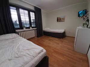 a bedroom with a bed and a refrigerator and window at Warszawska in Legionowo