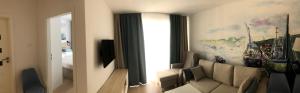 ein Wohnzimmer mit einem Sofa und einem Fenster in der Unterkunft Nadmorskie Tarasy Apartament 312 in Kołobrzeg