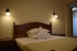 a bedroom with a bed with white sheets and pillows at Vila Preciosa in Alba Iulia