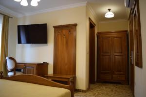 a bedroom with a bed and a desk and a television at Vila Preciosa in Alba Iulia