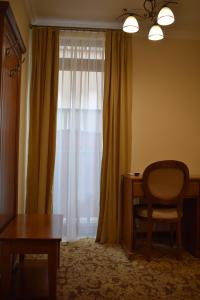 a room with a chair and a table and a window at Vila Preciosa in Alba Iulia