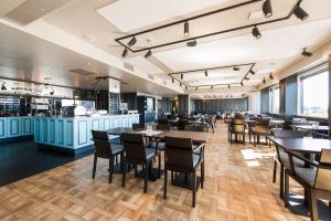 a restaurant with tables and chairs and a bar at Thon Partner Hotel Victoria Hamar in Hamar