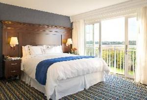 um quarto com uma cama grande e uma janela grande em Newport Beach Hotel & Suites em Middletown