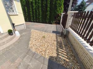 une terrasse couverte avec une clôture et un tas de rochers dans l'établissement Apollo Vendégház, à Bogács