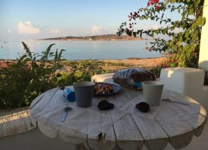 een tafel met een bord eten en uitzicht op de oceaan bij Palio Karnagio Παλιό Καρνάγιο in Koufonisia