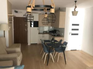 eine Küche und ein Esszimmer mit einem Tisch und Stühlen in der Unterkunft Nadmorskie Tarasy Apartament 312 in Kołobrzeg