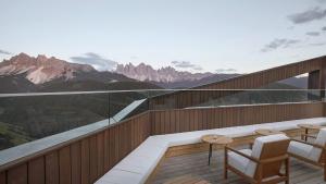 een balkon met een tafel en stoelen en bergen bij Forestis Dolomites in Bressanone