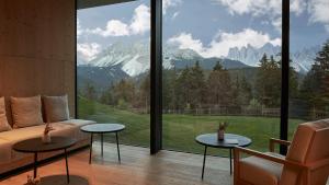 een woonkamer met een bank en een groot raam bij Forestis Dolomites in Bressanone