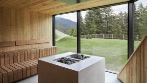 een kamer met een open haard en een groot raam bij Forestis Dolomites in Bressanone