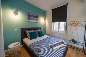 - une chambre avec un lit aux murs bleus et verts dans l'établissement L'île de la Brèche, à Niort