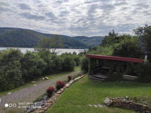 a garden with a building next to a lake at Chata pri Vode in Kelča