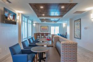 阿什维尔Holiday Inn Express & Suites Asheville Downtown, an IHG Hotel的带沙发和桌椅的等候室