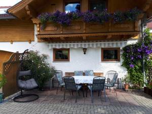 een tafel en stoelen voor een huis met bloemen bij Apartment Haus Dengg in Mauterndorf