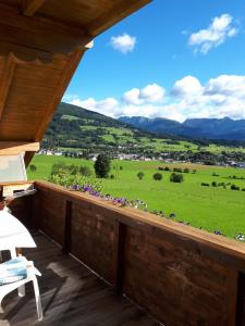 een balkon met uitzicht op een groen veld en de bergen bij Apartment Haus Dengg in Mauterndorf