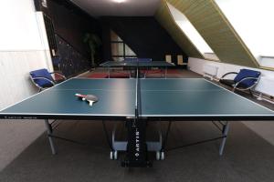 tavolo da ping pong in una stanza con sedie di Hotel Skicentrum a Harrachov