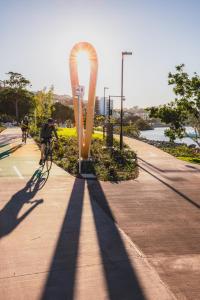 Un uomo che va in bicicletta lungo un marciapiede di View Brisbane a Brisbane