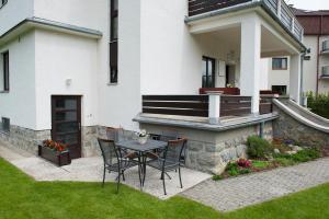 eine Terrasse mit einem Tisch und Stühlen vor einem Haus in der Unterkunft Vila Mala Marta in Tatranská Lomnica