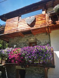 een gebouw met een balkon gevuld met bloemen bij Maison Le Cler in Valtournenche