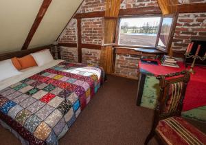 a bedroom with a bed and a chair and a window at Baltā māja in Pilsrundāle