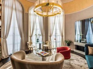 sala de estar con mesa, sillas y lámpara de araña en Raffles Europejski Warsaw, en Varsovia