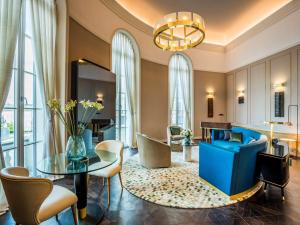 sala de estar con sofá azul y mesa en Raffles Europejski Warsaw, en Varsovia