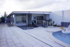 a house with a swimming pool in front of it at Casinha das Bonecas - Casa com Piscina Privada in Aveiro