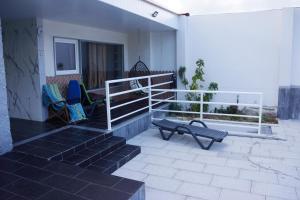 a patio with two chairs and a bench on a house at Casinha das Bonecas - Casa com Piscina Privada in Aveiro