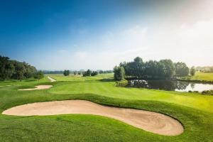 Blick auf einen grünen Golfplatz mit einem Teich in der Unterkunft Ferienwohnung Wolfgang Halbinger in Bad Griesbach