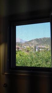 ventana en una habitación con vistas a la ciudad en iliolithos rooms, en Kardhamili