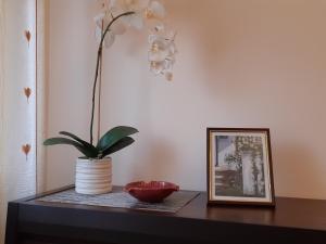 uma mesa com uma planta num vaso e uma imagem em Akord Apartment Centrum with FREE PARKING em Pärnu