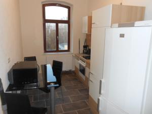 a kitchen with a refrigerator and a table with chairs at Hostel im Medizinerviertel in Halle an der Saale