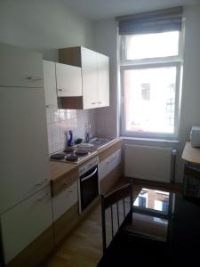 a kitchen with white cabinets and a window at Hostel im Medizinerviertel in Halle an der Saale