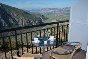 un tavolo e sedie su un balcone con vista di Acropole Delphi City Hotel a Delfi