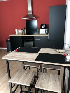 een keuken met een tafel, 2 stoelen en een aanrecht bij Grand appartement fonctionnel proche centre-ville in Saumur