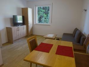 sala de estar con mesa, sofá y TV en Garni Sonnleiten, en Tirolo