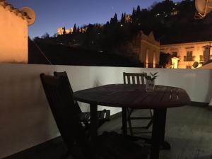 a wooden table and chairs on a balcony at night at Castle, Terrace and Relax in Tomar