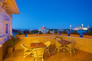 a patio with tables and chairs on a balcony at White House Hotel Istanbul in Istanbul