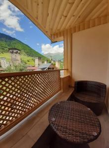 a balcony with a bench and a table and a window at Sanli in Mestia