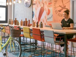 a man sitting at a table with a laptop at Ibis Madrid Getafe in Getafe