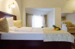 - une chambre avec un lit et une corbeille de fruits dans l'établissement Hotel Dorottya, à Kaposvár