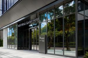 MGH Mitsui Garden Hotel Taipei Zhongxiao في تايبيه: مبنى زجاجي امامه لافته