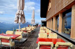 un restaurant avec des tables et des parasols sur un balcon dans l'établissement Berghaus Niederhorn, à Beatenberg