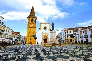 a church with a clock tower in a city at Castle, Terrace and Relax in Tomar