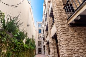 eine Gasse zwischen zwei Gebäuden mit einer Steinmauer in der Unterkunft Hotel Madero in Querétaro